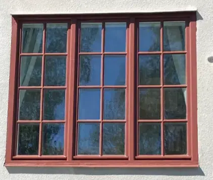 Renoverat träfönster med röd färg – resultat efter fönsterrenovering i Dalarna